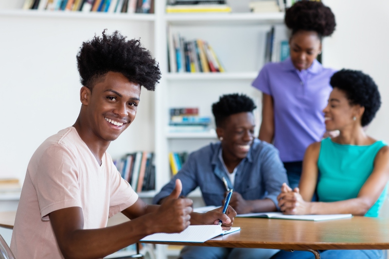 happy african american male student learning at desk at school
